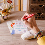 A person uses a red pen from the Inku Stationery Crate by Japan Crate to write a New Year& thumbnail 3
