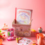 The Doki Doki Kawaii Crate by Japan Crate is displayed in a cute box, surrounded by Japanese plushies, toys, a teapot, cupcakes, flowers, and sticker sheets on a pink background. thumbnail 6