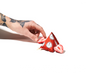 A tattooed hand holds Bokksu White Strawberry 1 Piece alongside sliced chocolate-infused strawberries and a red, pyramid-shaped package on a white background, evoking the distinctive snacks from a Bokksu Snack Box inspired by Nagano, Japan. thumbnail 3