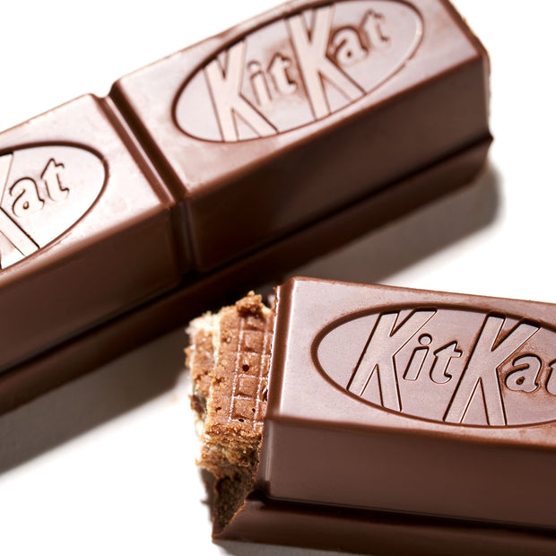 Two Japanese Kit Kat: Original Bars from Nestle Japan, one with a bite taken out showing the layers inside, isolated on a white background.