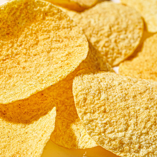 A close-up of Lay's Potato Chips: Braised Pork flavor, featuring their circular, textured shape in a pile, highlighting the golden color and savory seasoning.