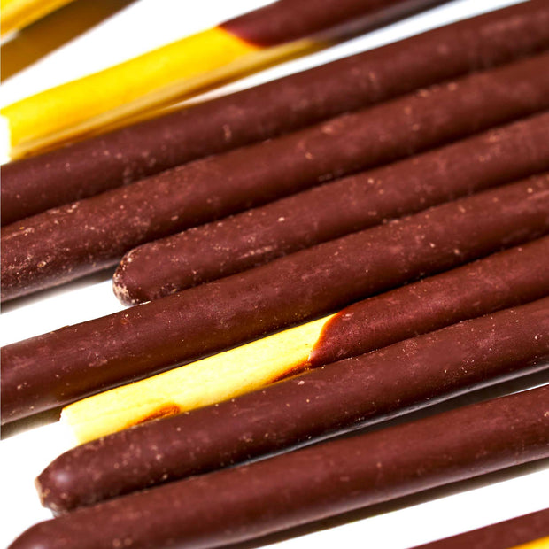 Close-up of several Glico Pocky: Ultra Slim Chocolate biscuit sticks arranged in parallel on a white surface, reminiscent of the classic treat.