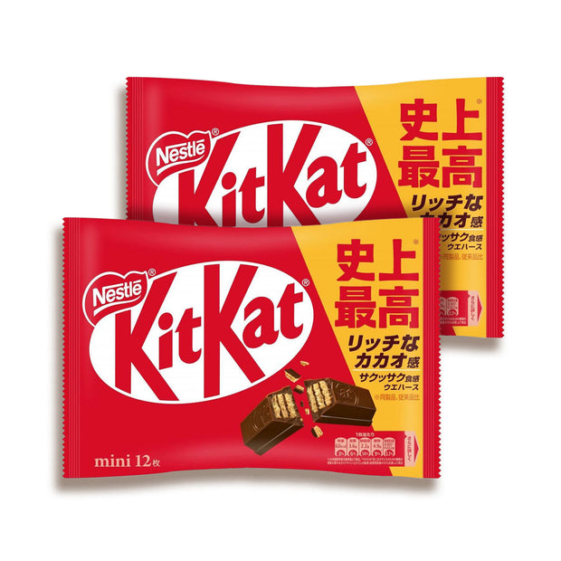 Two packs of Nestle Japan's Japanese Kit Kat: Original Chocolate feature red and white branding with chocolate wafer bar images. Enjoy a delightful break with this candy in its recyclable packaging adorned with unique Japanese text.