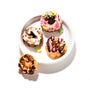 A delightful assortment of four miniature donuts, each embellished with various icings and sprinkles, is beautifully presented on a white plate, with one donut placed beside it. Create these enjoyable treats using the DIY Candy Kit Pack (6-Pack) from Bokksu Market for a fun homemade candy-making experience that captures the joy of Kracie creations. thumbnail 5