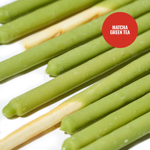 Close-up of several Glico Pocky biscuit sticks from the Glico Pocky: Variety Pack (6-Pack), shown with a vibrant matcha green tea coating and arranged diagonally on a white surface.