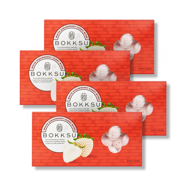 Four Bokksu Market White Strawberry Japanese Candy Bites boxes are arranged with some overlapping, each showing images of white strawberries and the freeze-dried candy bites enrobed in creamy white chocolate on the front.