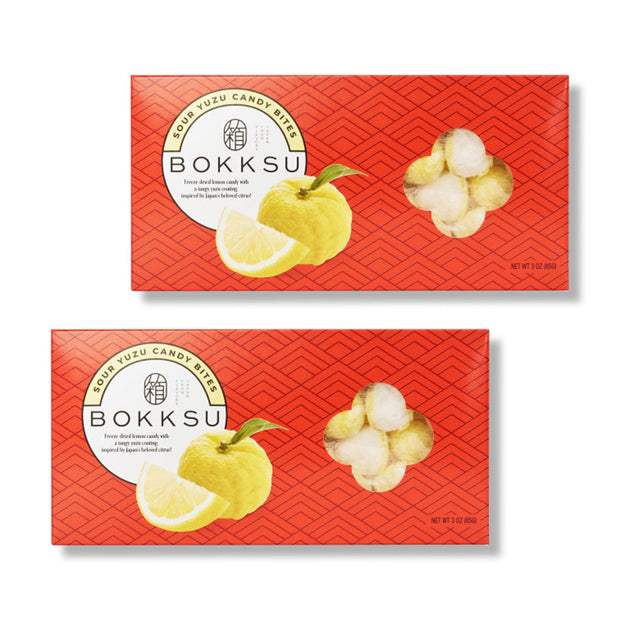 Two red boxes of Bokksu Market Sour Yuzu Japanese Candy Bites (2-Pack), featuring yuzu fruit, lemon slices, and freeze-dried candy pieces on the front.