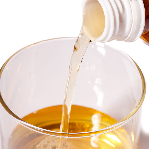 A bottle of Itoen Jasmine Green Tea is being poured into a glass.