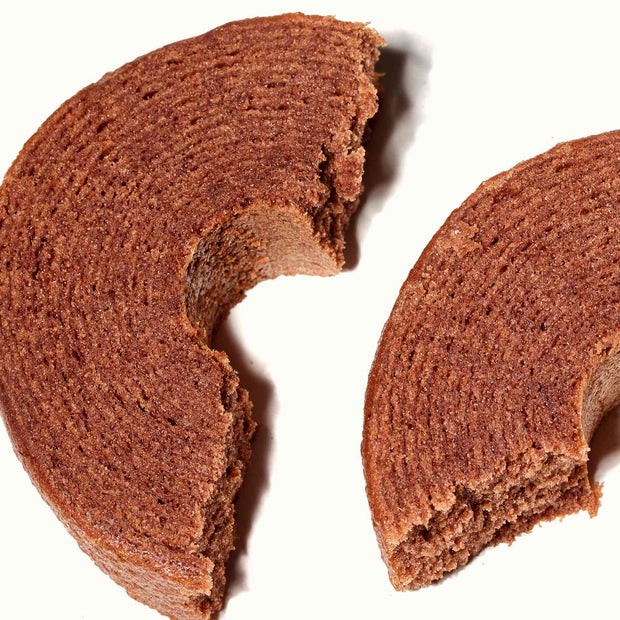 A slice of Suzuya Mini Baumkuchen: Chocolate cake on a white surface.