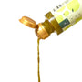 A plastic bottle of Bokksu Yuzu Hot Sauce by Bokksu, topped with a yellow cap, is tilted and pouring a stream of vibrant sauce against a white background. thumbnail 4