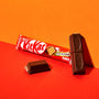 A Nestle Japan Japanese Kit Kat chocolate bar with original packaging beside an unwrapped bar showing two separated pieces on a red-orange background. thumbnail 2