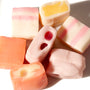A group of UHA Mikakuto Puchao Gummy Candy: Fruit Mix in juicy flavors on a white surface. thumbnail 2