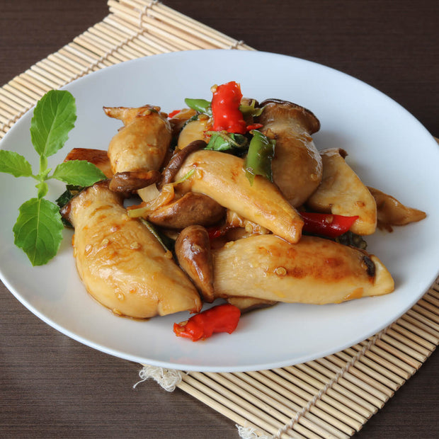 A plate of Japanese cuisine featuring spicy Ocean Foods Yuzu Kosho Pepper: Red Label mushrooms and peppers.