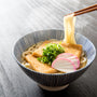 A bowl of noodle soup with Kikkoman Hon Tsuyu Soup Base and chopsticks in it. thumbnail 4